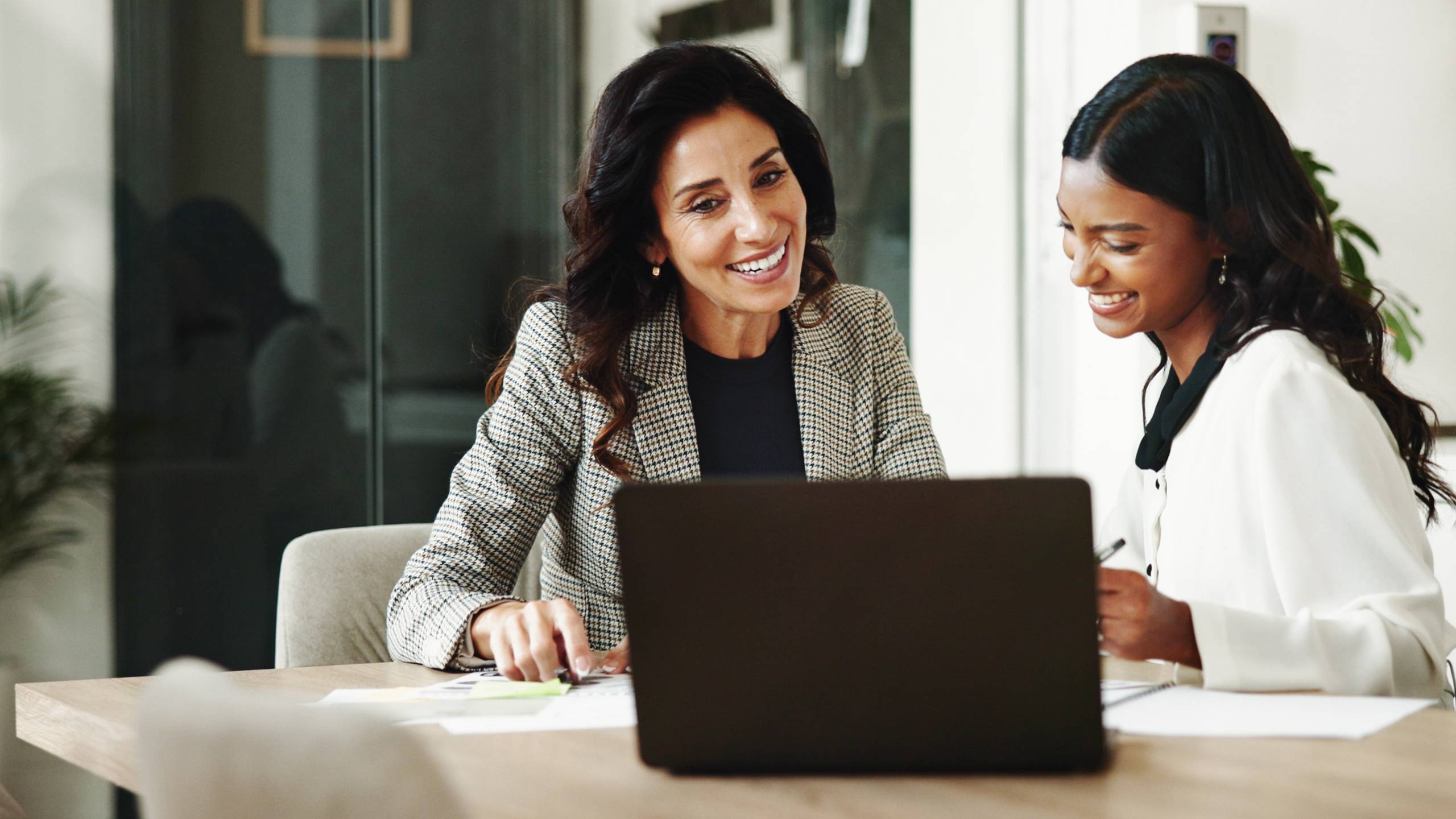 Two business women meeting with laptop and notes-featured