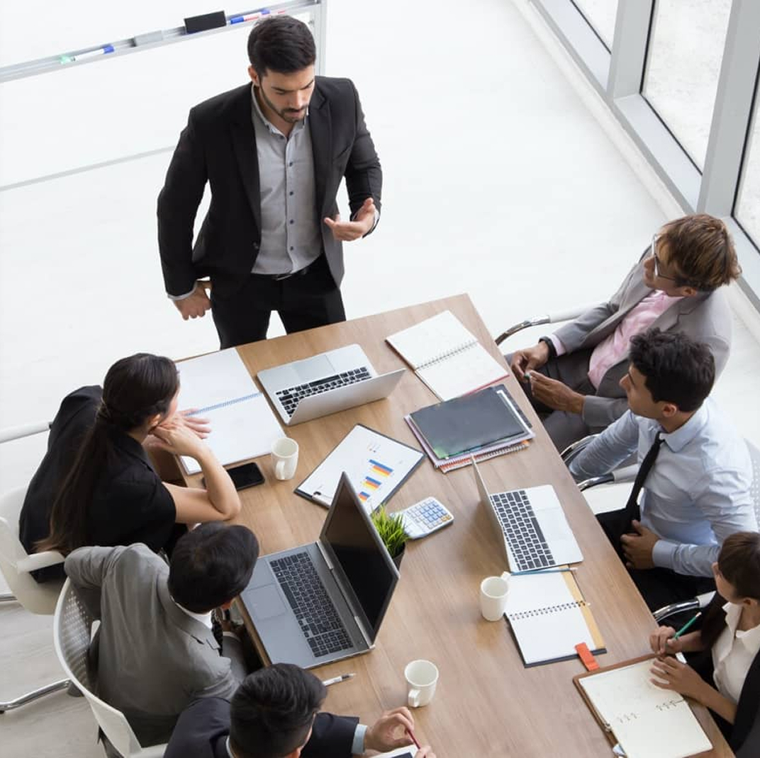 business man doing presentation to group of people around table